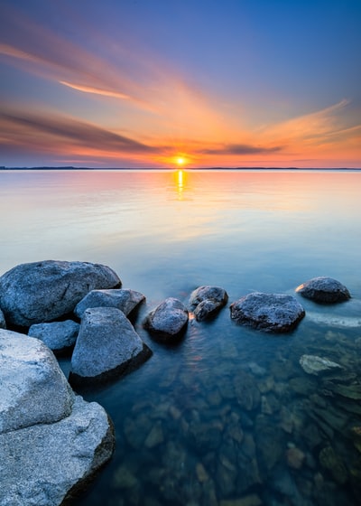 日落时水体上的灰色岩石